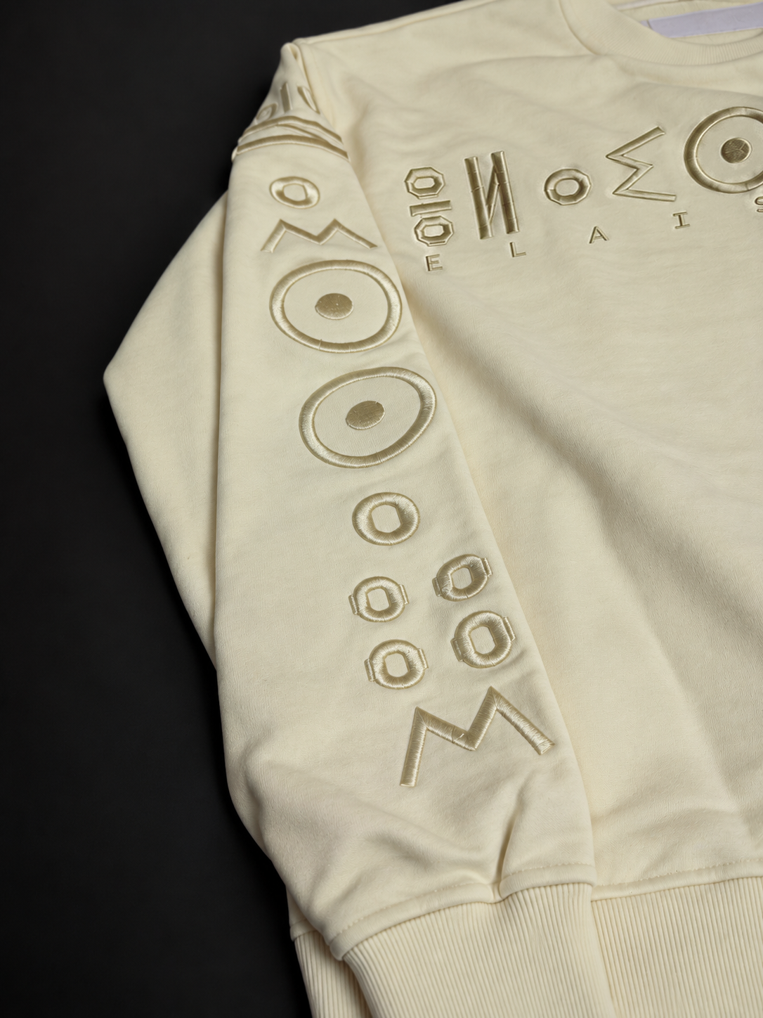 Close-up of the raised tonal embroidery on the TICHKA sleeve and chest by ELAISSAOUI.
